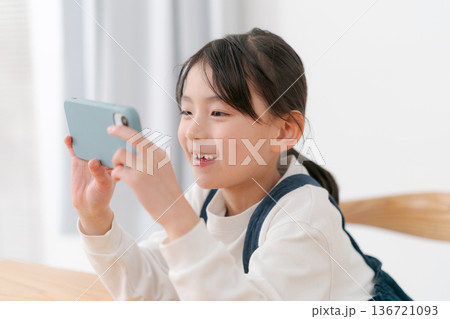 スマホで遊ぶ小学生の女の子 136721093