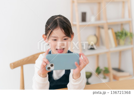 スマホを見る小学生の女の子 スマホを見る小学生の女の子 136721368
