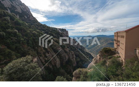 Panoramic view of the majestic Montserrat mountains and monastery buildings perched on a steep cliff in Catalonia, Spain. A breathtaking natural and historic landmark 136721450