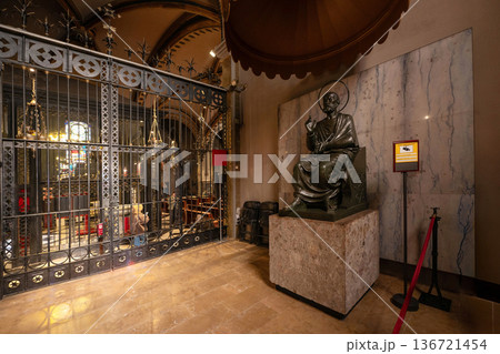 Montserrat Monastery in Spain, featuring an ornate iron gate, religious paintings, and a grand organ pipe system under a vaulted ceiling 136721454