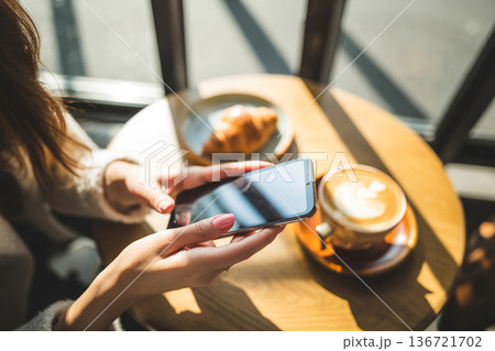 カフェでスマートフォンを操作する女性の手元 Generative AI カフェでスマートフォンを操作する女性の手元 Generative AI 136721702