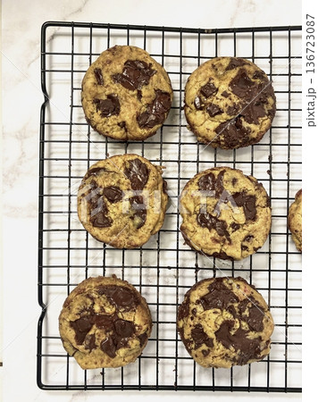 Freshly baked cookies with a golden-brown finish and chocolate chips. Perfectly crisp on the edges with a soft center, offering a delicious, comforting treat for any occasion. 136723087
