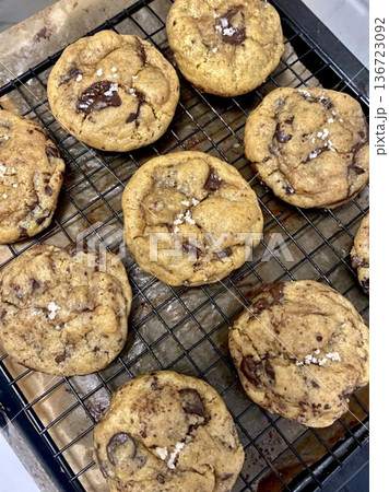 Freshly baked cookies with a golden-brown finish and chocolate chips. Perfectly crisp on the edges with a soft center, offering a delicious, comforting treat for any occasion. 136723092