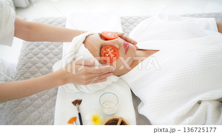Masseuse masking face with tomato and spa face woman treatment and massage aroma therapy relax Masseuse masking face with tomato and spa face woman treatment and massage aroma therapy relax 136725177