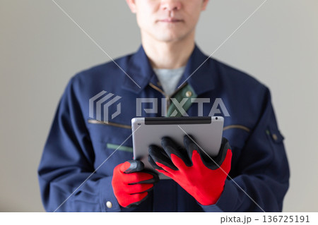 タブレットを持つ作業服のミドル男性ビジネスマン タブレットを持つ作業服のミドル男性ビジネスマン 136725191