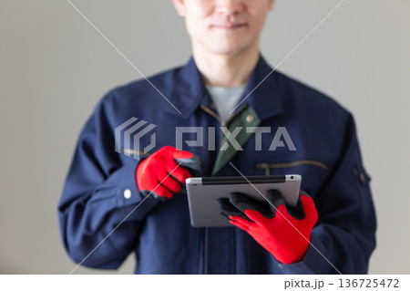 タブレットを持つ作業服のミドル男性ビジネスマン タブレットを持つ作業服のミドル男性ビジネスマン 136725472