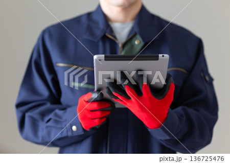 タブレットを持つ作業服のミドル男性ビジネスマン 136725476