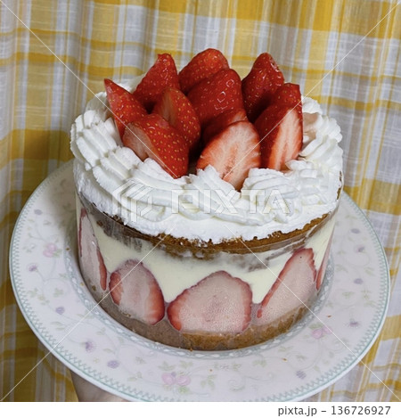 Strawberry cake with soft fluffy layers, topped with fresh strawberries and smooth cream, showcasing vibrant red fruit, delicate textures, and sweet inviting appearance in close-up detail 136726927