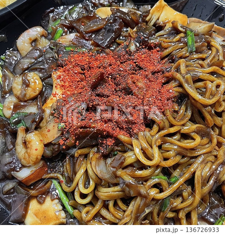 Classic jajangmyeon with thick noodles in a rich black bean sauce, garnished with sliced cucumber and sesame seeds. A beloved Korean-Chinese comfort dish, full of savory depth and flavor. 136726933