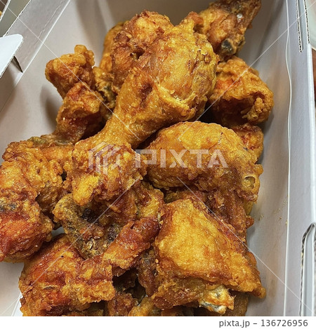 Crispy Korean fried chicken, perfectly glazed with a sweet and spicy sauce. Ideal for food photography and menus, showcasing the irresistible crunch and flavor of this beloved dish. 136726956