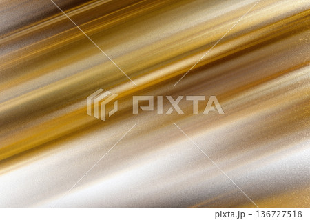 Luxurious golden brushed steel texture with vibrant yellow light reflections and textured metallic surface 136727518