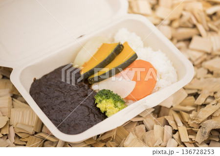 ウッドチップの上に置かれたテイクアウトのカレーライス 136728253
