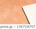 オレンジ背景に映えるノート 136728707