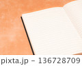 オレンジ背景に映えるノート 136728709