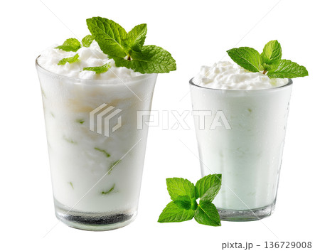 Ayran salted yogurt drink in tall glass with foamy top and mint leaf, isolated on white background, concept of healthy drink Ayran salted yogurt drink in tall glass with foamy top and mint leaf, isolated on white background, concept of healthy drink 136729008