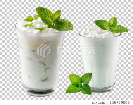 Ayran salted yogurt drink in tall glass with foamy top and mint leaf, isolated on white background, concept of healthy drink Ayran salted yogurt drink in tall glass with foamy top and mint leaf, isolated on white background, concept of healthy drink 136729008