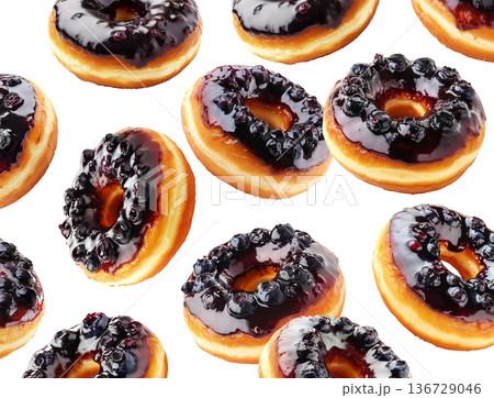 Multiple blueberry glazed donuts with shiny icing and berries scattered in a seamless pattern on white background 136729046