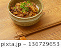 木目調テーブルに置かれた牛丼と箸の和食イメージ 136729653