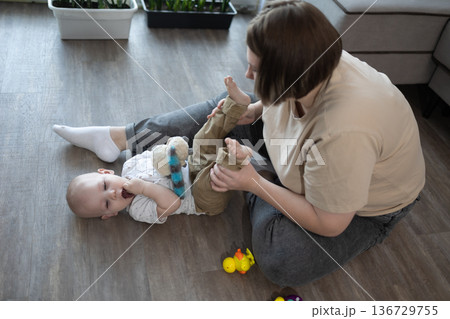 Mother Tenderly Calms Baby. Peaceful Scene Of Mother Soothing Child In Cozy Home Environment Mother Tenderly Calms Baby. Peaceful Scene Of Mother Soothing Child In Cozy Home Environment 136729755
