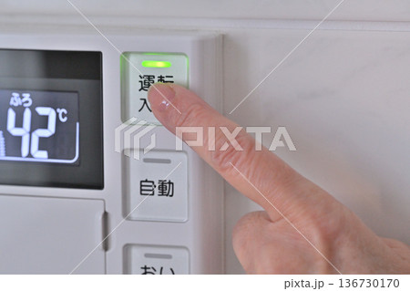 給湯器リモコンのボタンを押す 136730170