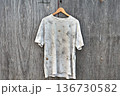 合板にぶら下がっている汚れた白Tシャツ 136730582