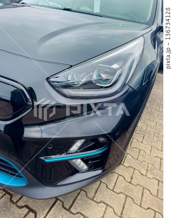 Close view of a black electric car parked in a lot in daylight showing modern design and features Close view of a black electric car parked in a lot in daylight showing modern design and features 136734128