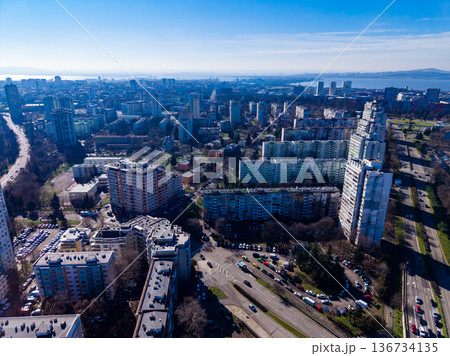City view showing buildings, roads, and open spaces during daytime in an urban area with clear skies and distant mountains 136734135