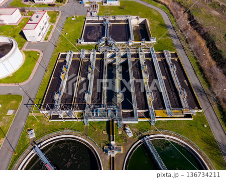Water treatment facility located in a city, showing clean water processes and equipment during daytime with clear skies Water treatment facility located in a city, showing clean water processes and equipment during daytime with clear skies 136734211