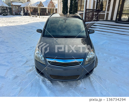 Car parked in snowy area near houses on a bright winter day with clear skies in the background Car parked in snowy area near houses on a bright winter day with clear skies in the background 136734294