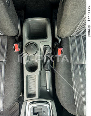Central console and gear shift of a car showing storage areas and seating arrangement for two front seats Central console and gear shift of a car showing storage areas and seating arrangement for two front seats 136734351