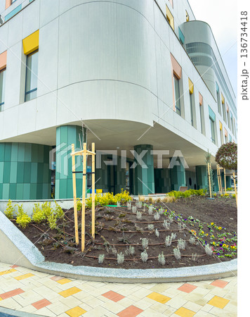 Colorful building with a landscaped garden in front and light-colored pathway on a cloudy day 136734418