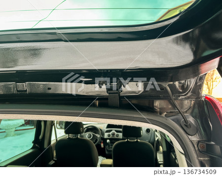View of car interior showing the hatch area and parts of the rear seat during the day near a house in a suburban area View of car interior showing the hatch area and parts of the rear seat during the day near a house in a suburban area 136734509
