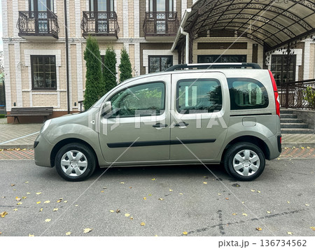 Silver vehicle parked by a building during daytime with greenery in the background and a canopy over the parking area Silver vehicle parked by a building during daytime with greenery in the background and a canopy over the parking area 136734562