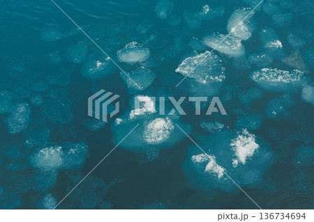 Melting ice floats on water in a large body of water during a clear summer day in the Arctic region Melting ice floats on water in a large body of water during a clear summer day in the Arctic region 136734694