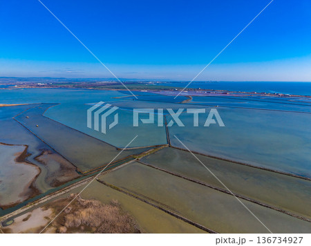 Vast fields of water and land with canals and patches seen from above on a sunny day near the coast Vast fields of water and land with canals and patches seen from above on a sunny day near the coast 136734927