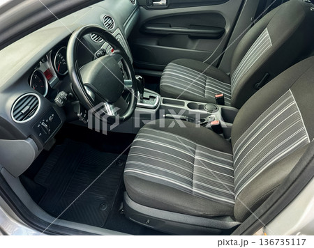 Interior of a car showing front seats and dashboard during daylight in a city parking area Interior of a car showing front seats and dashboard during daylight in a city parking area 136735117