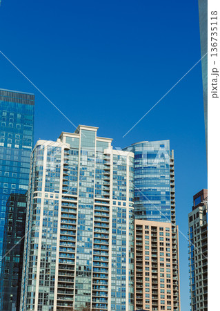 Skyline of modern buildings in a city under bright blue sky during daylight hours Skyline of modern buildings in a city under bright blue sky during daylight hours 136735118
