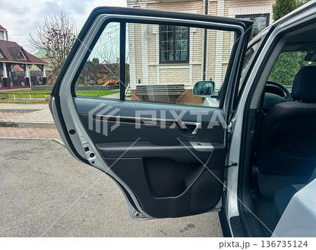 Car door opens beside house in a suburban area during the day with cloudy sky and no visible people nearby Car door opens beside house in a suburban area during the day with cloudy sky and no visible people nearby 136735124