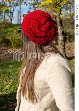 Woman in red knit beret in autumn park Woman in red knit beret in autumn park 136735739
