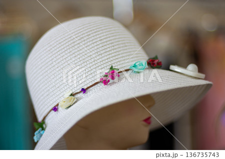 White wide-brim sun hat with floral band on mannequin White wide-brim sun hat with floral band on mannequin 136735743