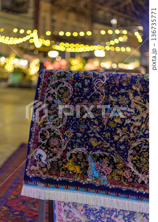 Ornate handwoven rug on display with festival lights Ornate handwoven rug on display with festival lights 136735771