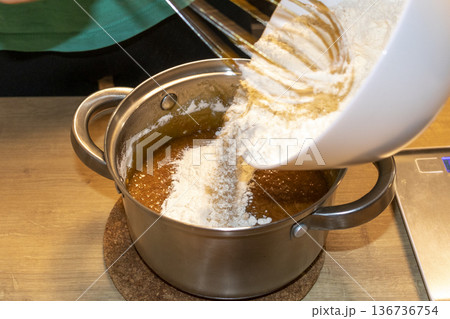A person whisks the sauce in a pot 136736754
