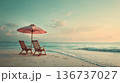 Two wooden deck chairs under umbrella on beach 136737027