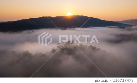 Aerial view of beautiful sunrise over the sea of mist in the mountains. Aerial view of beautiful sunrise over the sea of mist in the mountains. 136737475