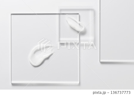White cosmetic skin care product on glass. White background. White cosmetic skin care product on glass. White background. 136737773