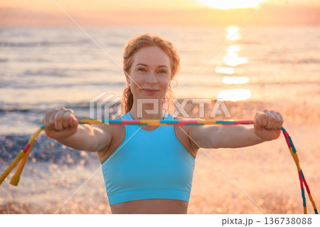 Fit woman jumping rope at the beach during vacation. Healthy lifestyle and summer sport concept Fit woman jumping rope at the beach during vacation. Healthy lifestyle and summer sport concept 136738088