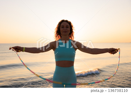Fit woman jumping rope at the beach during summer vacation 136738110