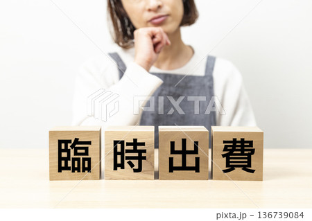 「臨時出費」と書かれたブロックとエプロン姿の女性 136739084