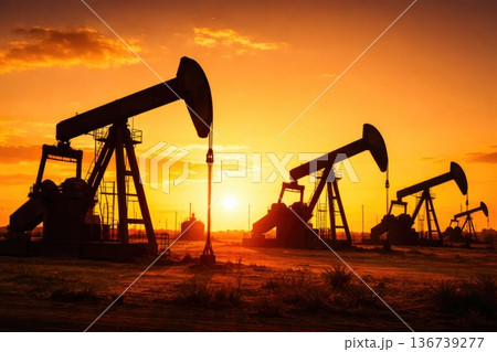 Oil pump jacks silhouettes at sunset in industrial field energy production concept Oil pump jacks silhouettes at sunset in industrial field energy production concept 136739277