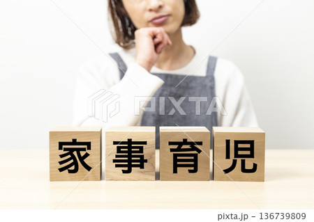 「家事育児」と書かれたブロックとエプロン姿の女性 136739809